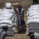 An Ethiopian woman stands by sacks of wheat to be distributed by the Relief Society of Tigray in the town of Agula, in the Tigray region of northern Ethiopia Saturday, May 8, 2021. (AP Photo/Ben Curtis, File)